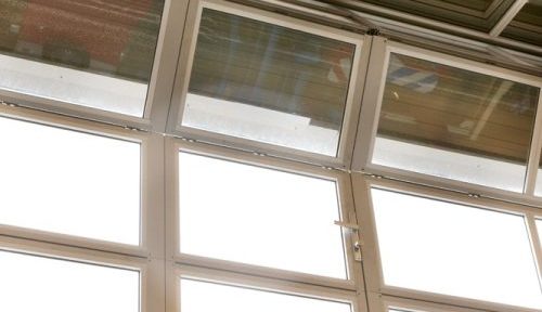 Nærbillede af industriport med gangdør og glaspaneler i aktion Nærbillede af industriport med gangdør og glaspaneler i aktion