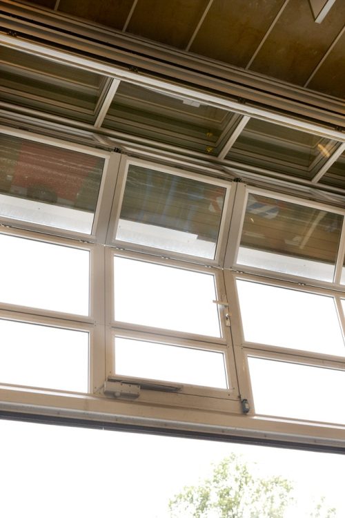 Nærbillede af industriport med gangdør og glaspaneler i aktion Nærbillede af industriport med gangdør og glaspaneler i aktion