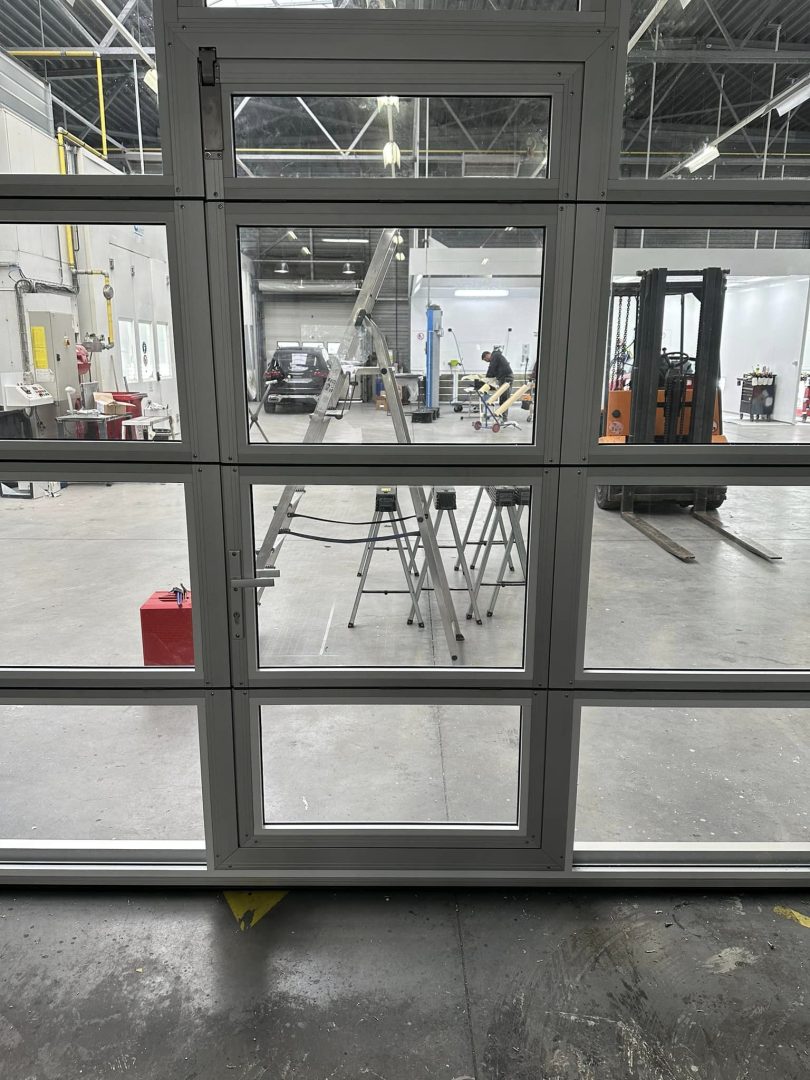 Nærbillede af industriport med gangdør og glaspaneler Nærbillede af industriport med gangdør og glaspaneler