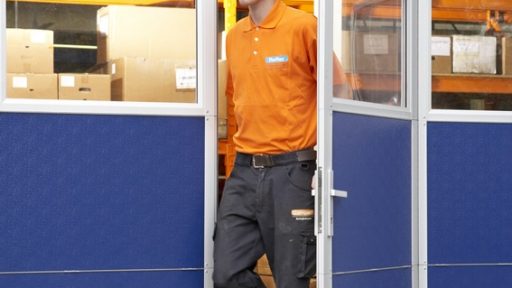 Schlupftür in blauem Compact Falttor in einer Produktionshalle Schlupftür in blauem Compact Falttor in einer Produktionshalle