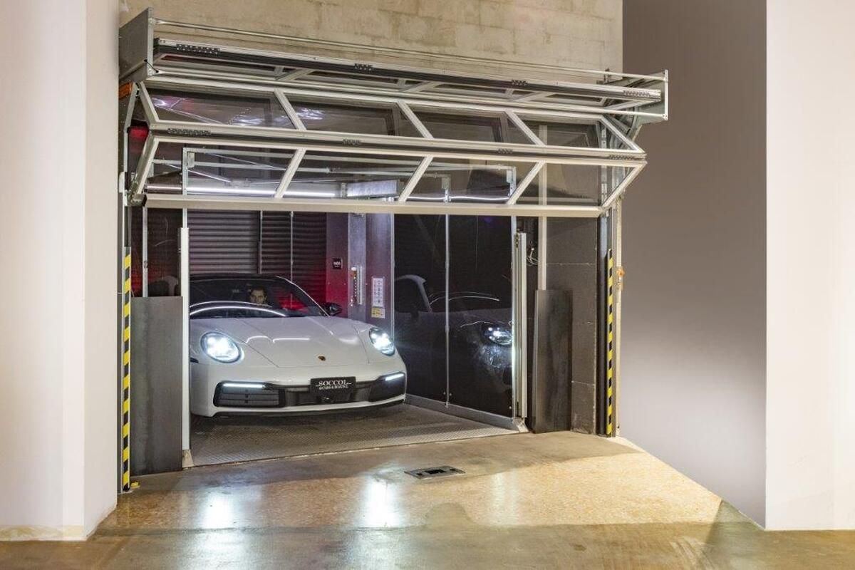 Porsche fährt aus dem Autolift das mit Compact Toren verschlossen wird