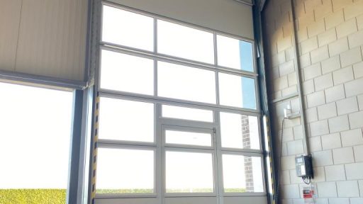 Schlupftür in einem hohen Tor mit Glaspaneelen Schlupftür in einem hohen Tor mit Glaspaneelen