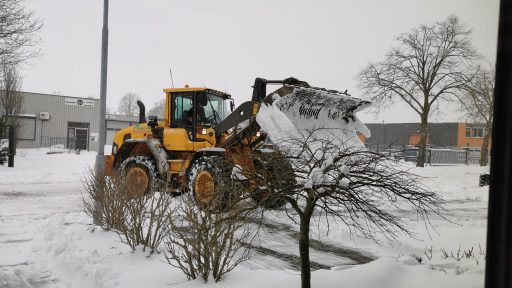 Wheel loader pushes snow from the parking lot