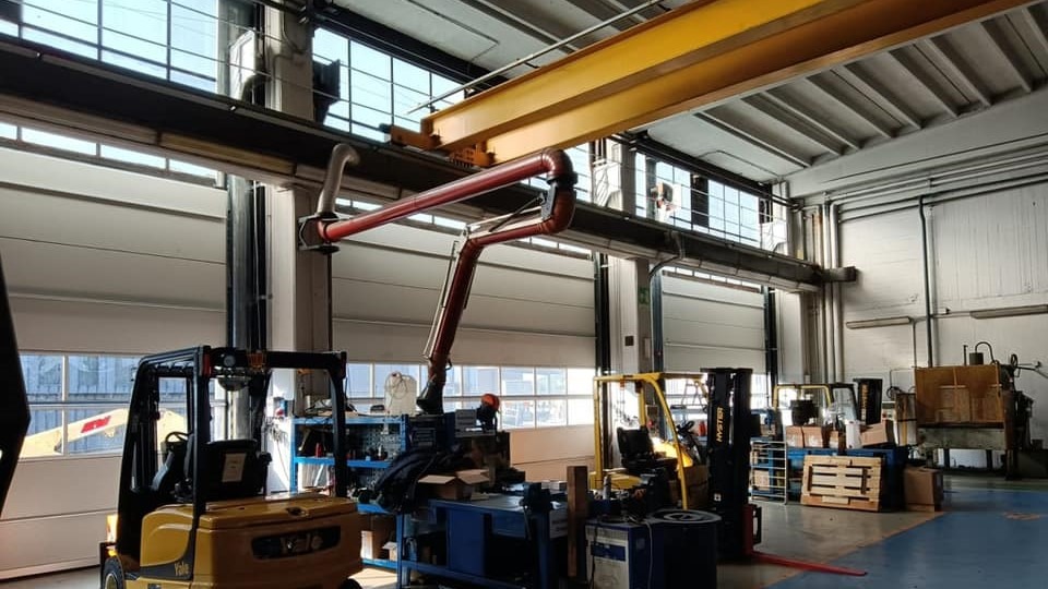 Compact sectional overhead door with a crane track directly behind the door