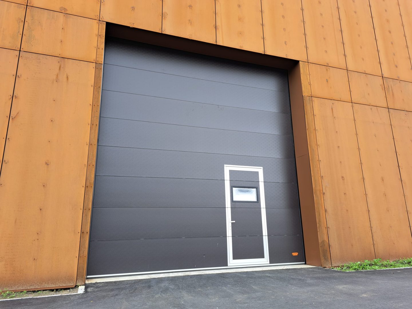 Industrial doors with wicket door at Alliander Westpoort from outside - Rolflex