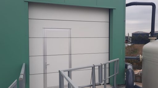Porte enroulable avec portillon pour bâtiment de traitement des eaux