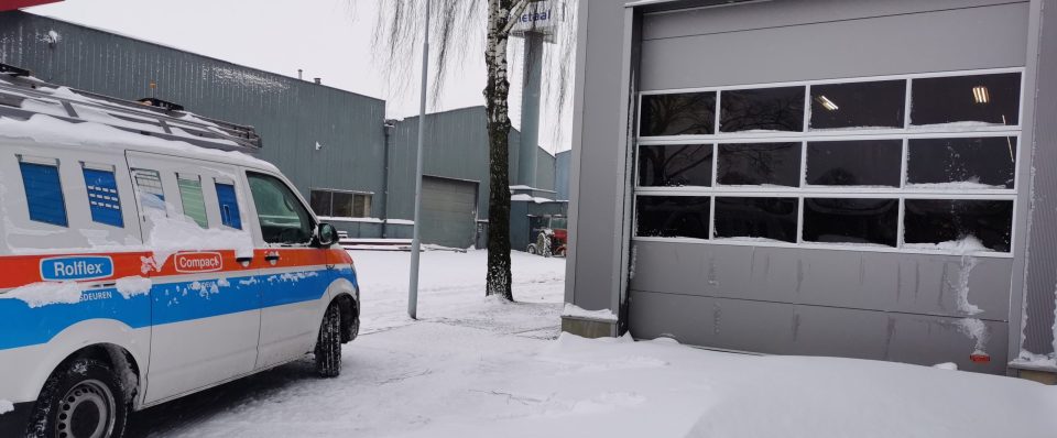 Compact deur in de sneeuw met Rolflex-bus ervoor