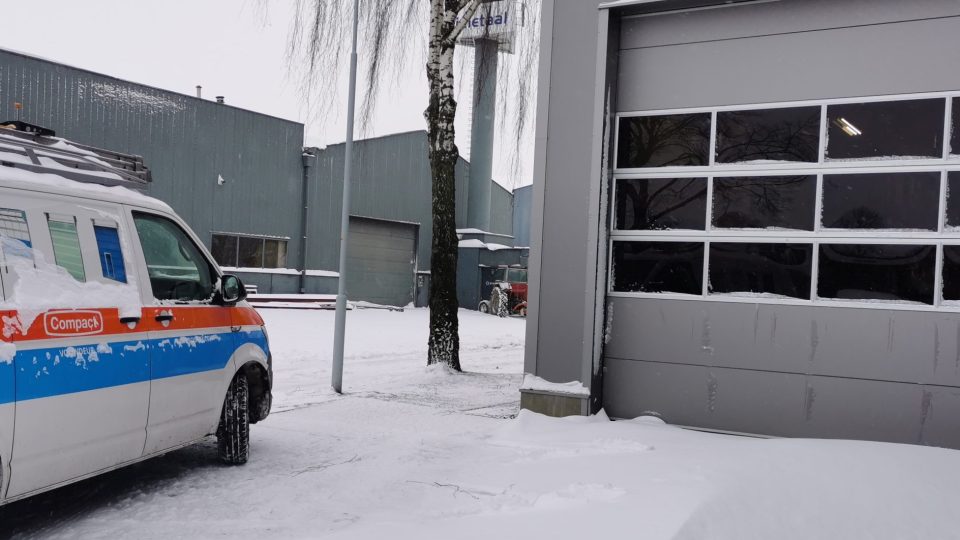 Compact deur in de sneeuw met Rolflex-bus ervoor